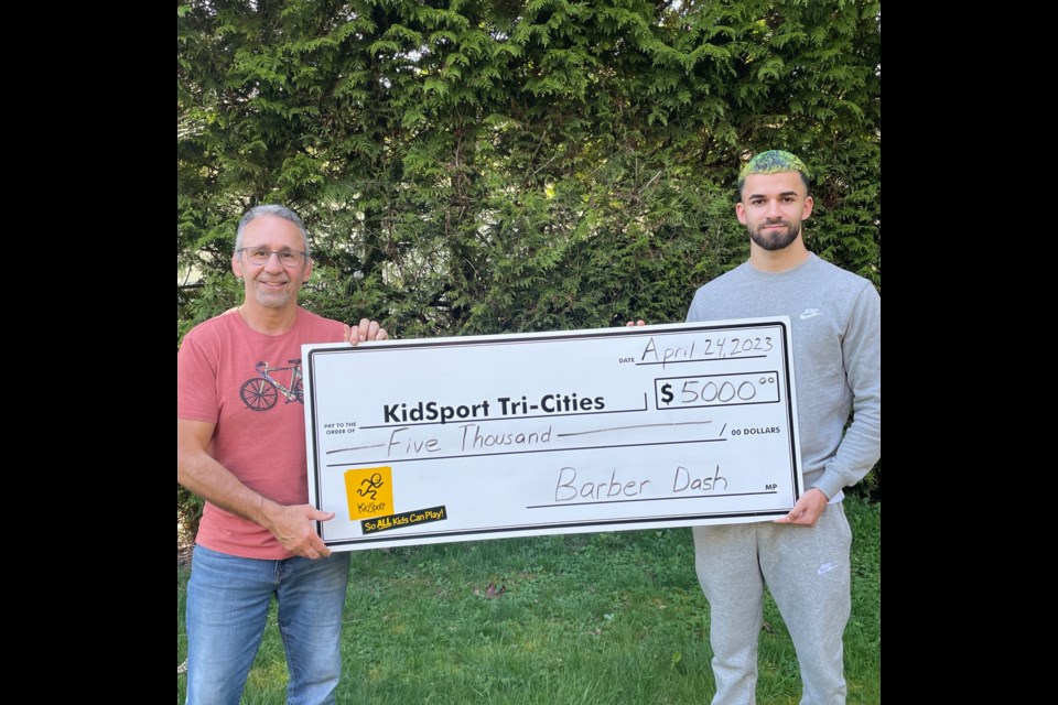 Justin Karbowiak (right), owner of Barber Dash, donates $5,000 to KidSport Tri-Cities' Chris Wilson.