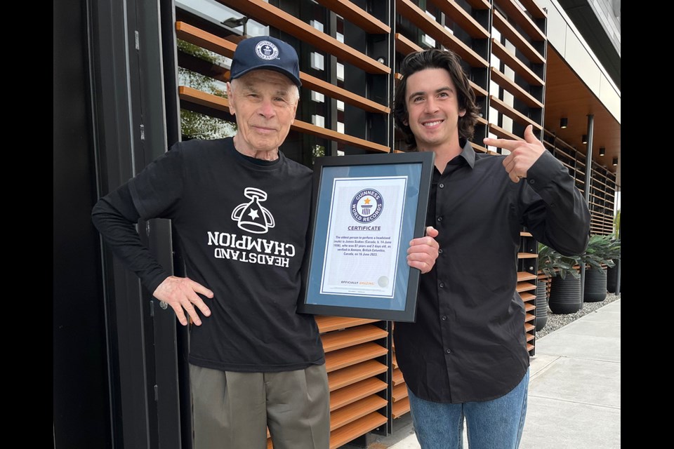 James Szakos, 87, and his grandson, Milton, show off his certificate from Guinness World Records authenticating his world record headstand.