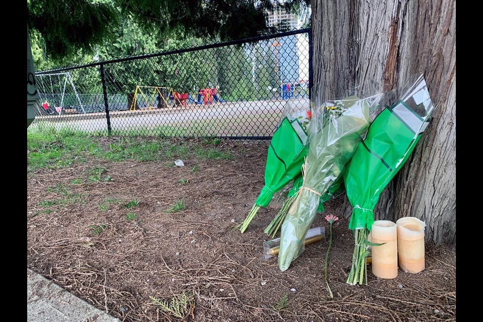 A makeshift memorial, including flowers and candles, has been created at the foot of a tree by Coquitlam's Glen Elementary to honour the life of a 29-year-old man who died of a fatal, "not random" stabbing the morning of May 8, 2022.