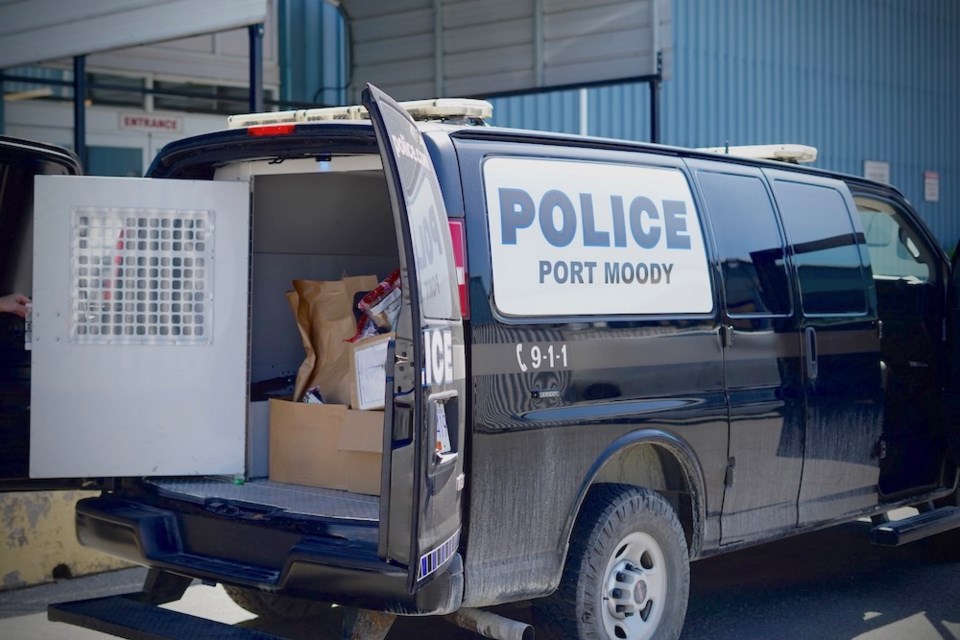 Hundreds of documents are carted away in a Port Moody Police Department van.            