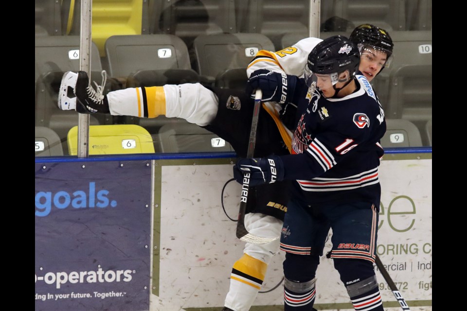 Coquitlam Express defenceman Matthew Campbell is hit into the boards by Cowichan Valley Capitals forward Kevin-Thomas Walters in the first period of their BC Hockey League game, Sunday at the Poirier Sport and Leisure Complex.
