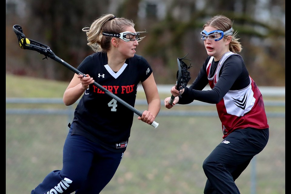 Jolaine Bolam, a Grade 8 student at Eagle Mountain Middle School, plays defence for the Heritage Woods Kodiaks in an exhibition girls field lacrosse game against the Terry Fox Ravens. The informal nature of the formative four-team league allows schools to fill out their rosters with players from neighbouring schools.