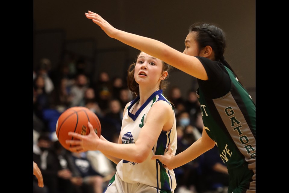 Avery Sussex, of the Riverside Rapids, looks for a shot past a Walnut Grove defender in the first half of their BC High School girls AAAA basketball semifinal, Friday at the Langley Events Centre.