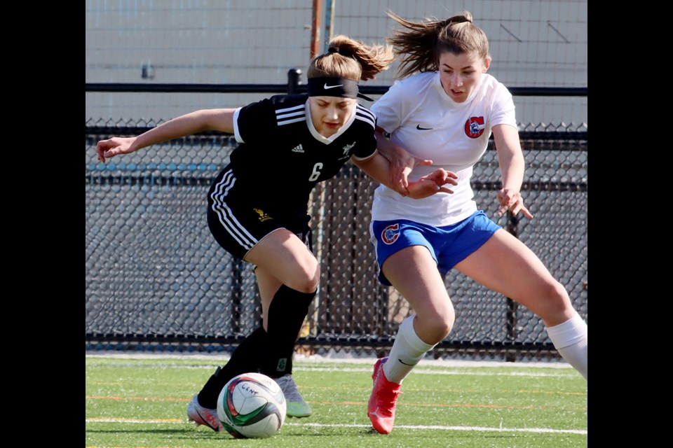 Kiera Scott of the Centennial Centaurs battles a Terry Fox Ravens defender for the ball in the first half of their Fraser North senior girls AAA soccer match, Tuesday at the new turf field at Centennial Secondary School.