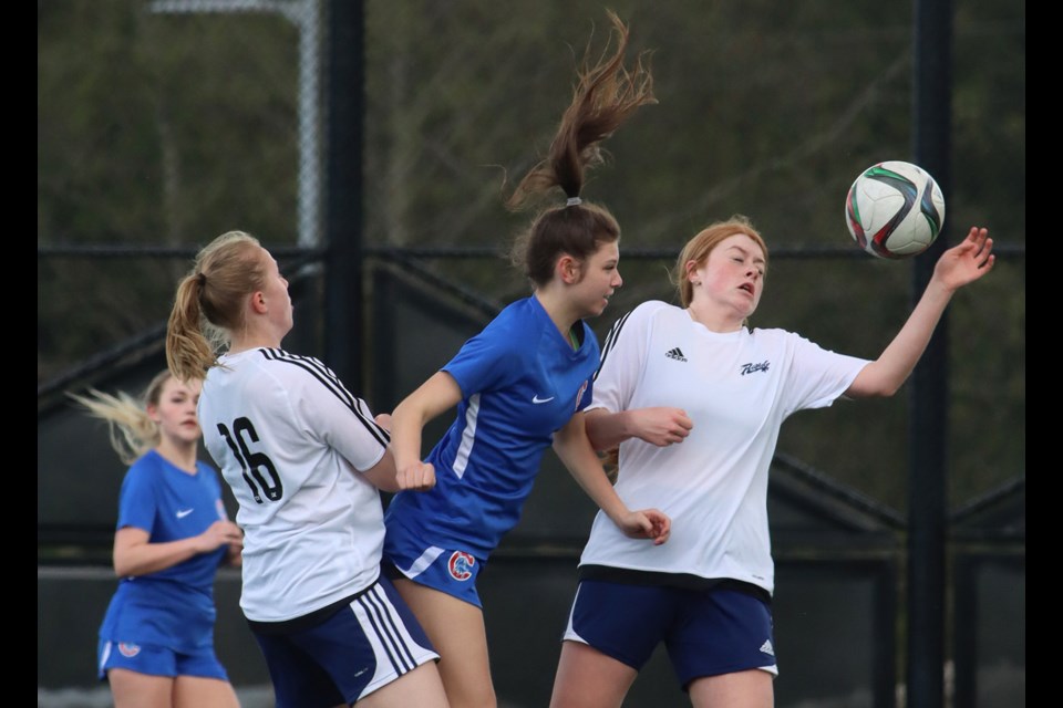 Centennial Centaurs' forward Jamie Lynn Schmidt battles Riverside Rapids defenders Olivia Wheatley and Madison Hoegler for control of a header in the first half of their Fraser North AAA girls high school soccer match, Tuesday at Centennial Secondary School. The Centaurs won 9-0.