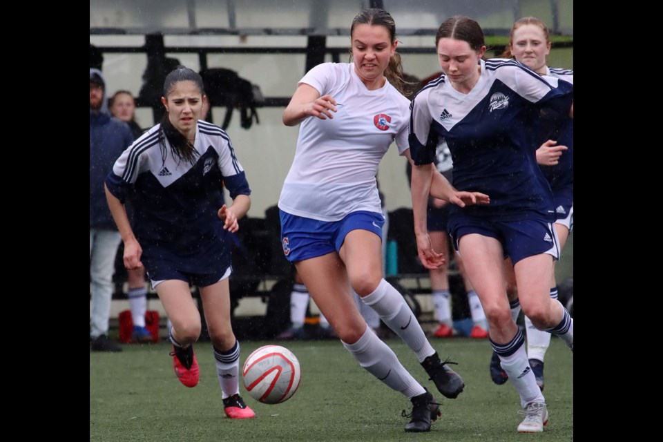 Centennial Centaurs forward Tara Krsmanovic charges between Riverside Rapids' defenders Hila Tata and Sammy Kerr in the first half of their Fraser North senior girls high school soccer match, Thursday at Gates Park in Port Coquitlam. Centennial won, 2-0.