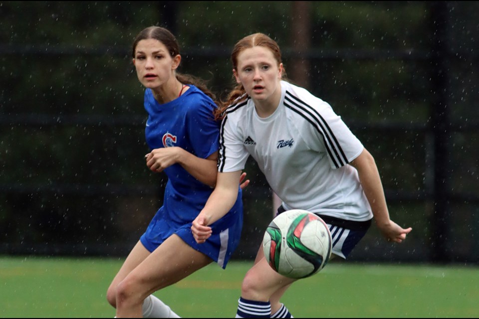 Centennial Centaurs Hannah Scott and Riverside Rapids Emily Wezeman track the ball in the first half of their Fraser North senior girls soccer playoff match, Thursday at the Centennial turf field. The Centaurs won, 2-0.