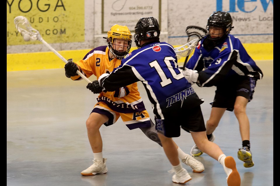 Coquitlam Adanacs Luke Banks tries to escape the checks of a pair of Langley defenders in their Bantam game at the 37th Trevor Wingrove Memorial lacrosse tournament, Friday at the Poirier Sport and Leisure Complex.