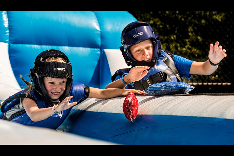 Emily Fedyushin (left) is racing her brother Alex, 9, in the bungee race at Coquitlam's annual sports fair at Town Centre Park on Saturday. The event offered families to try various sports and activities available in the community.