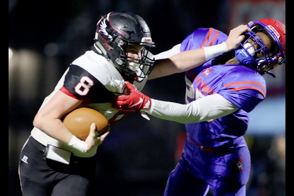 Terry Fox Ravens ball carrier Tristan Lindsay tries to escape the clutches of Centennial Centaurs defensive back Gael Tshibanda in the fourth quarter of their Coquitlam Bowl varsity football game, Friday at Centennial field. The Ravens won, 42-6.