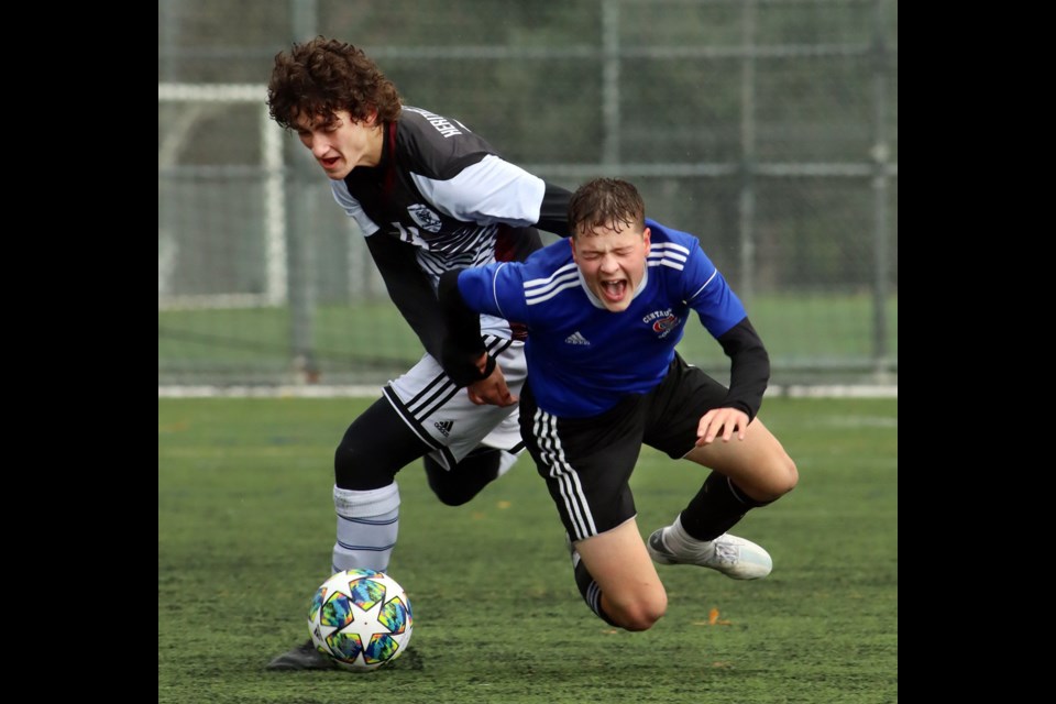 Centennial Centaurs Chase Doucette is tackled heavily by a Heritage Woods defender in their North Fraser Zone senior boys soccer playoff match, Wednesday at the Burnaby Lake Sports Complex West. Centenial won, 3-2, to capture the zone's third berth in the provincials.