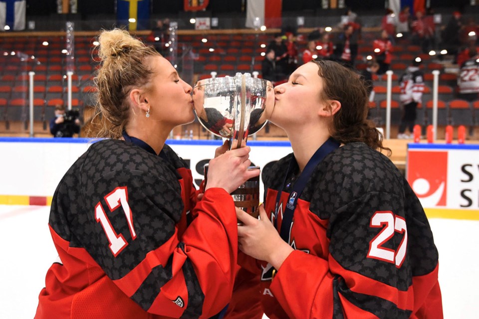 Reunited! Jordan Baxter (right) kisses the trophy after the Coquitlam forward helped Canada win the 2023 under-18 women's world hockey championship in Sweden — the second time in seven months.