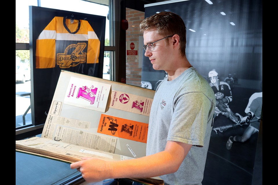 Alex Code, manager at the PoCo Museum and Archives, flips thorugh a scrap book collected by Mikes Gates, one of th ecity's great lacrosse players, that's part of a new display about the sport's history in Port Coquitlam.