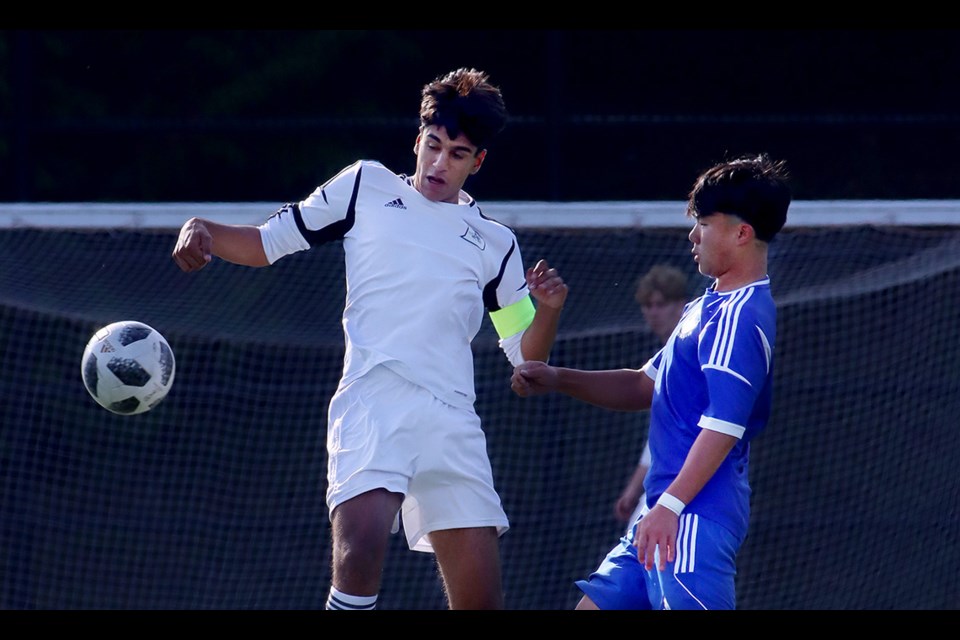 Pinetree Timberwolves Nicholas Lam and Armaan Sanghera-Gulamhussein of the Dr. Charles Best Blue Devils battle for control of.a header in the first half of their Coquitlam Secondary Schools Athletic Association senior boys soccer match, played last Thursday, Sept. 28 at Town Centre Stadium.