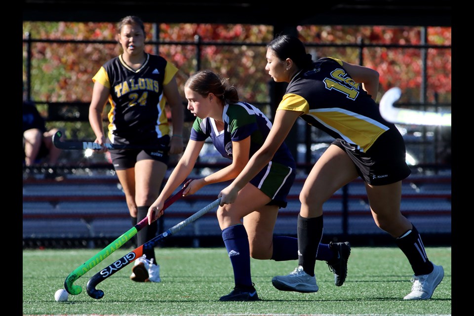 Riverside Rapids forward Alexa Walters breaks through Gleneagle Talons defenders Nyomi Khau and Penelope McKee in the first quarter of their Coquitlam Secondary Schools Athletic Association field hockey match, Thursday at Town Centre Park. Gleneagle won 2-0. Kora Henderson scored both goals.