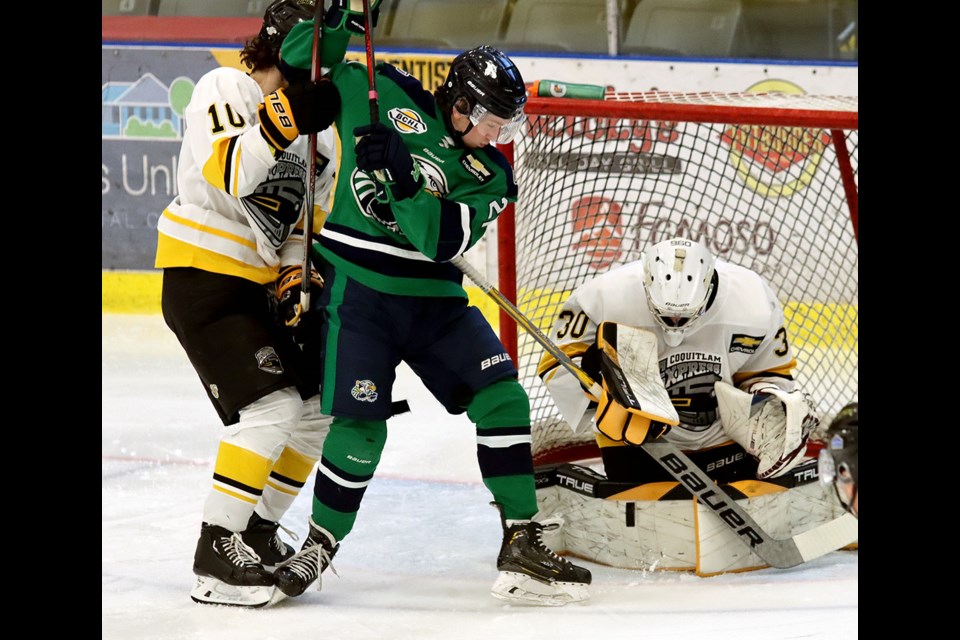 Coquitlam Express goalie Eric Young makes a save early in his first BC Hockey League game as defenceman Luke Vardy ties up Surrey Eagles forward Caden Cranston looking for a rebound.
