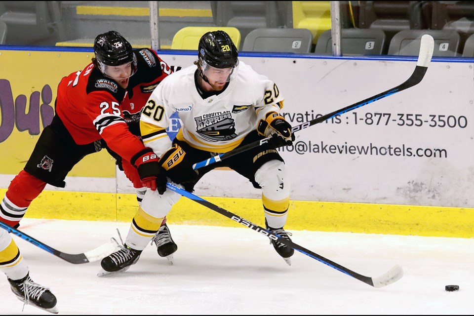 Coquitlam Express winger Cole Melady tries to escape the check of Alberni Valley Bulldogs defender Fischer O'Brien in the first period of their BC Hockey League playoff game, Wednesday at the Poirier Sport and Leisure Complex.