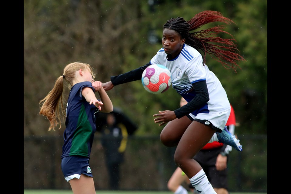 Ketsia Tshibang wins a header for the Dr. Charles Best Blue Devils over a Riverside Rapids forward in the first half of their Fraser North senior girls high school soccer match, Thursday at Dr. Charles Best Secondary School. The Blue Devils won, 2-1.
