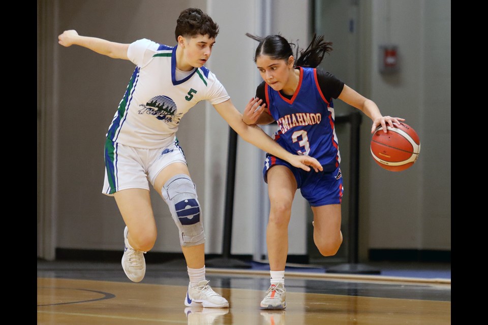 Riverside Rapids guard Mikella Campanile keeps a close check on Semiahmoo Thunderbirds Priya Sangha in the second half of their first round game at the Tsumura Invitational girls high school basketball tournament, Wednesday, Dec. 11, at the Langley Events Centre.