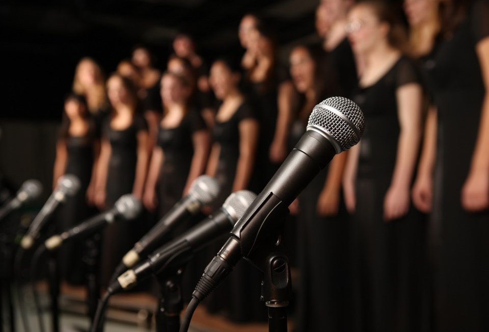 Choir with microphones stage singing - Getty Images