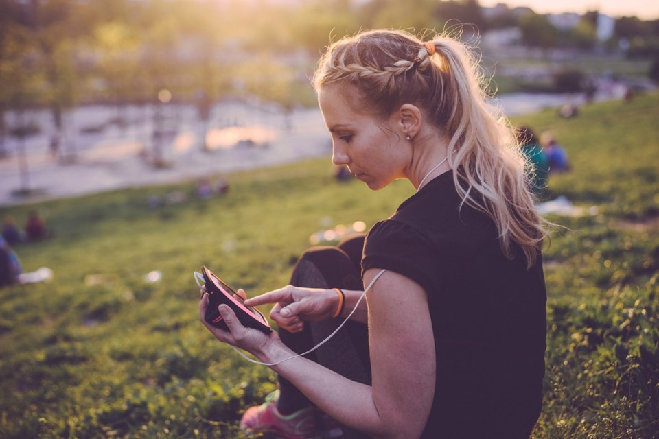 Person using cell phone in public park - Getty Images