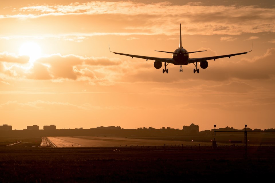 airplane-landing-in-sunset-getty-images