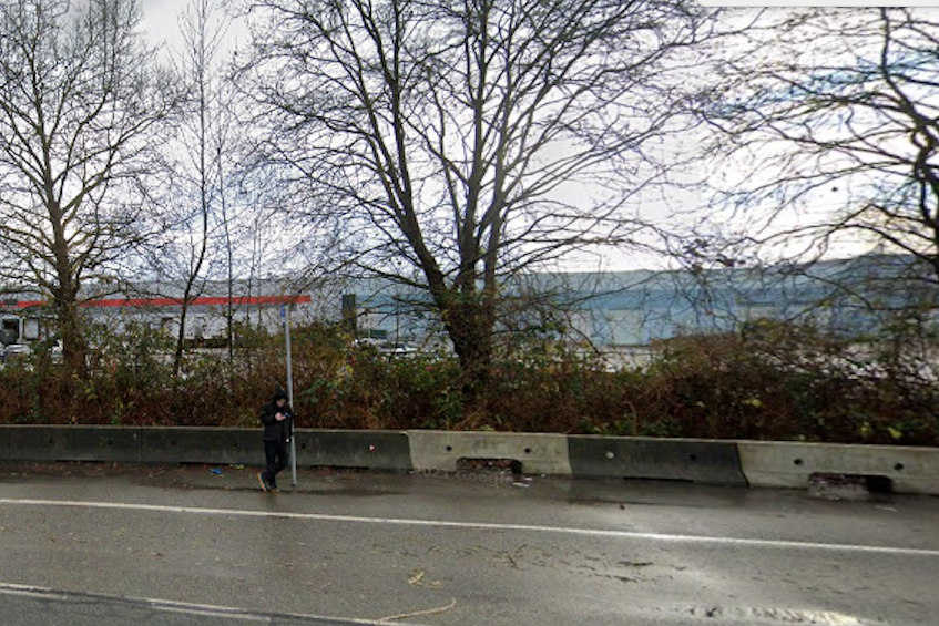 A transit rider waits for a bus next to the busy Mary Hill bypass in Port Coquitlam.