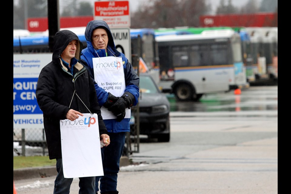Buses sit idle as picketers set up outside the Port Coquitlam Transit Centre on Monday.