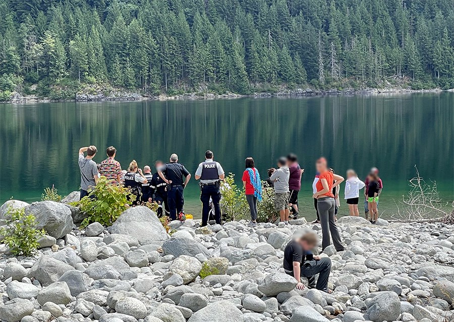 A group of bystanders, family members, and emergency responders at the scene of a drowning at Skwellepil Creek campsite on Chehalis Lake