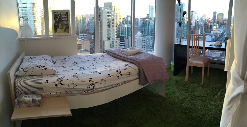 This "enclosed living room" in a downtown Vancouver apartment has a bookshelf, wardrobe, and curtain as a wall and door. 