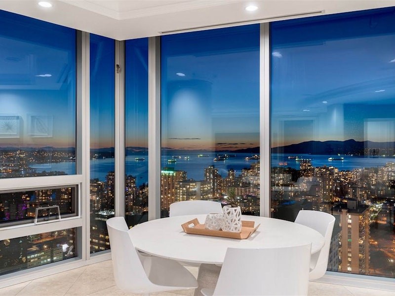 Table with a view set up in a corner space of this luxury 'sky home' with floor-to-ceiling windows custom-designed for a 'Hollywood action star' in downtown Vancouver. The unit is listed for just under $13 million.