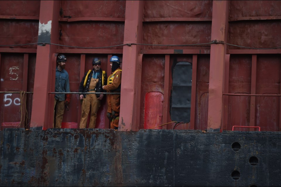 Workers on the beached barge at English Bay on Monday, Dec. 13, 2021. 