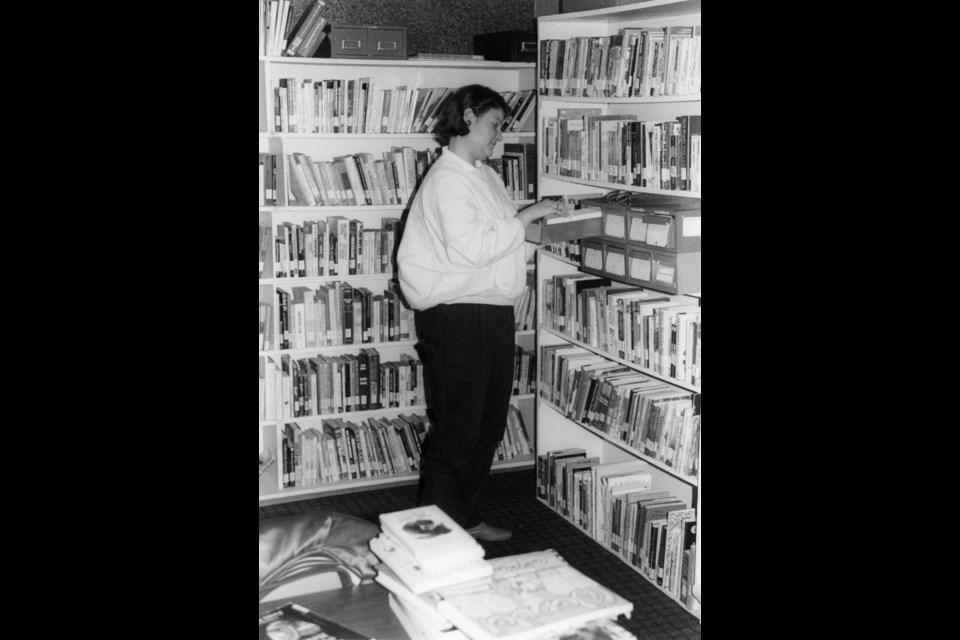 Donna Devos tends to the titles at the Out on the Shelves library.