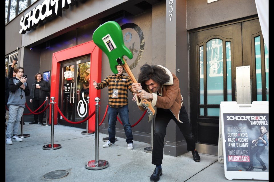 Charlie Kerr smashed a guitar in front of the School of Rock's new home (the old Yuk Yuks on Cambie).