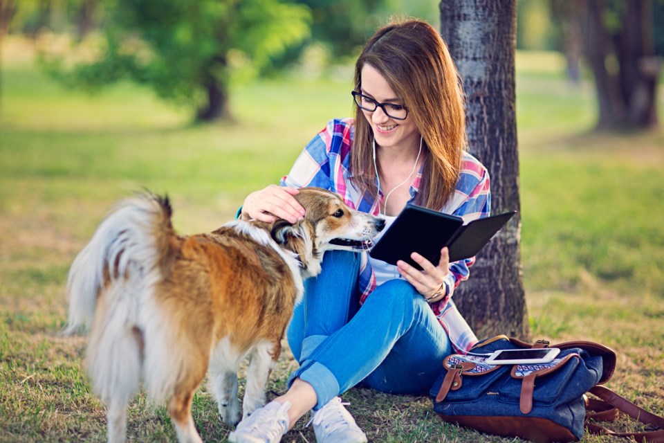 dog-woman-reading-in-park-praetorianphoto-E-GettyImages-542687888