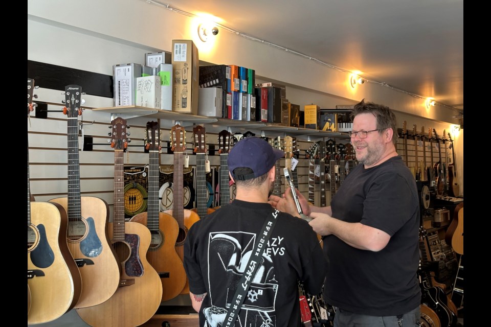 Chris Young, one of the owners of Exile Electronic explains a product to a customer. 