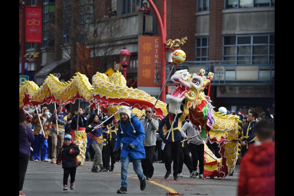 A pair flee the oncoming dragon during the Lunar New Year parade in Vancouver’s Chinatown on Jan. 22, 2023.