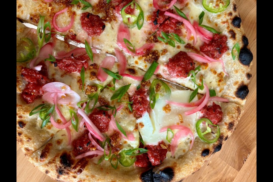 Just Pizza is a new indie pizza restaurant in Vancouver that has classic pies and more "adventurous" options, like the Filipino Breakfast, which has garlic white sauce, mozzarella, house-made longganisa sausage, sunny side up egg, jalapenos, pickled red onions, fried garlic, and scallions