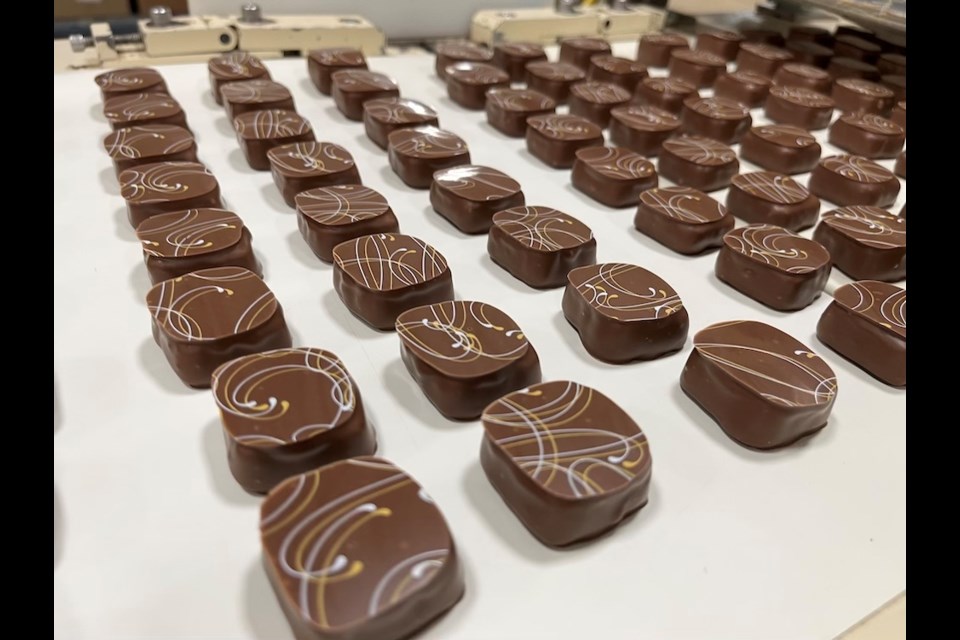While some chocolates have a decorative edible overlay, others are still hand stamped by workers, which means flavours have a distinct flourish pattern put on the chocolate exterior - it's those little curly swoops you'll see on the tops.