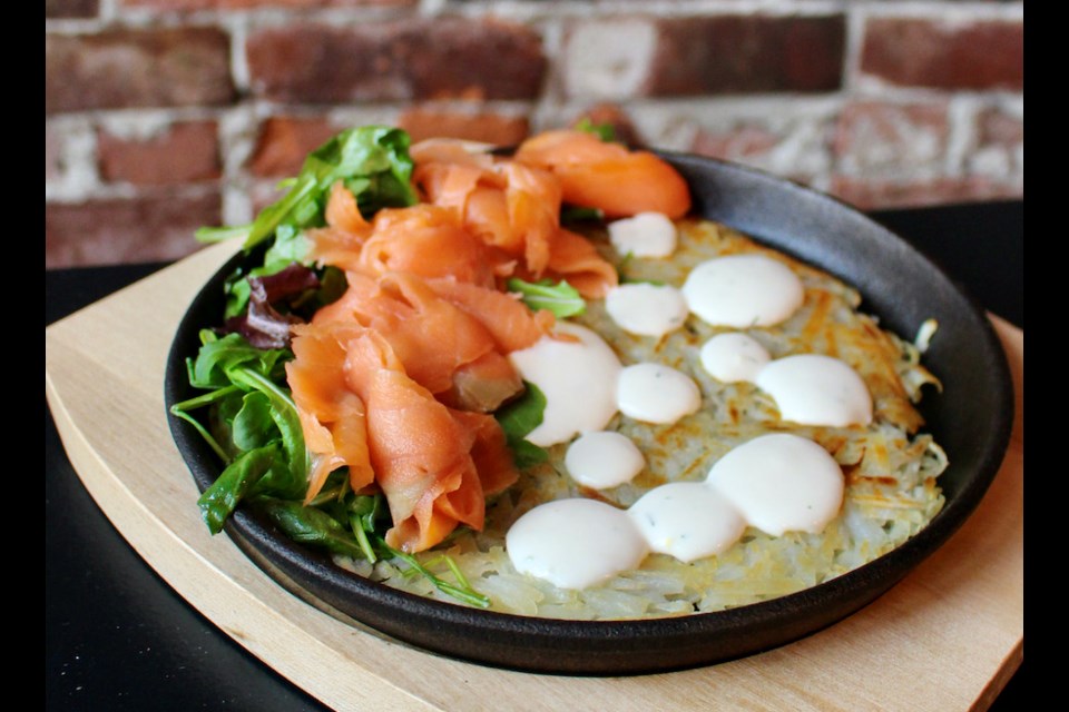 A smoked salmon potato pancake, or rösti, with dill creme fraiche and greens