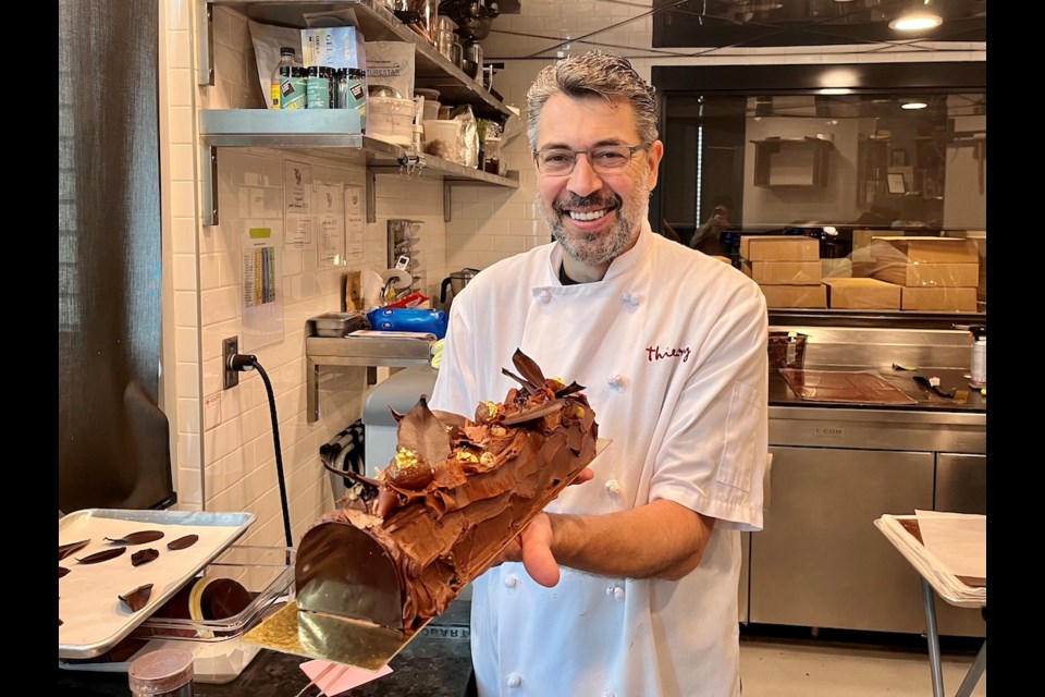 Chef Thierry Busset holds up his traditional Chestnut Buche de Noel inside his production kitchen at the Thierry Mount Pleasant location in Vancouver