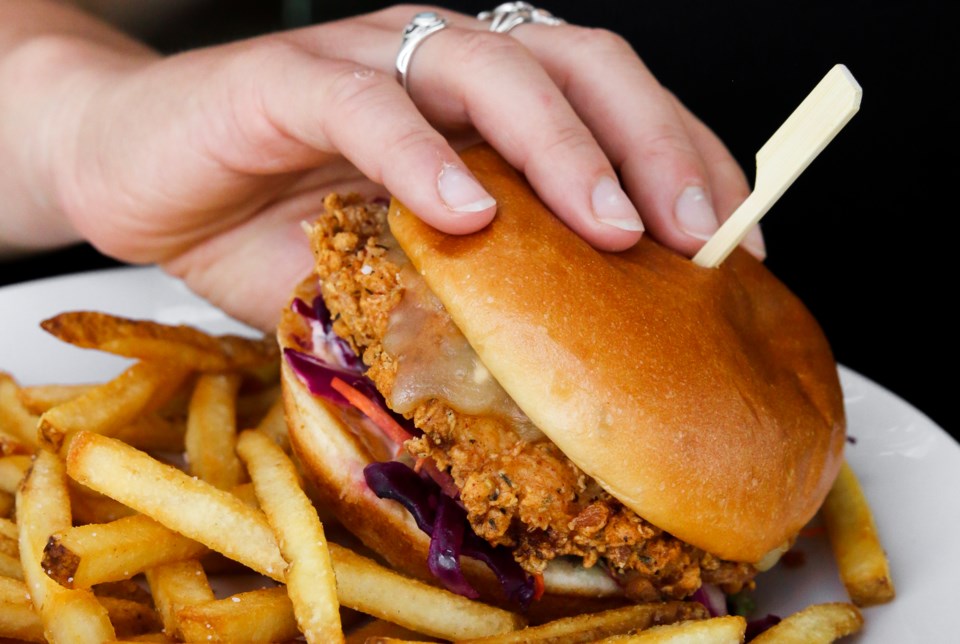 Woman eating burger stock Vancouver