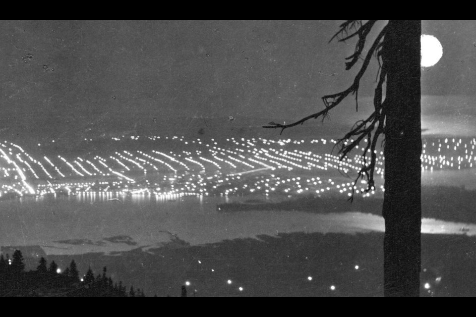 The photo includes Vancouver's Harbour, Stanley Park's Brockton Point and the moon's reflection on the Salish Sea.