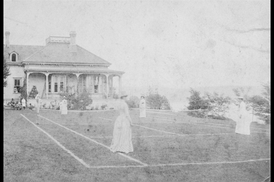 A group of women play tennis on a grass court in 1888 at the home of Benjamin Springer in Moodyville. He was an influential businessman in Vancouver. Mrs. Townley, Eva Springer, Mrs. Monte Woods are listed as people in the photo, but it doesn't say who is who. Reference code: AM54-S4-: Out P232