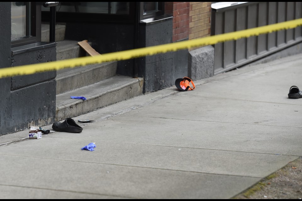 Items on the street in front of 842 Cambie St. include a pair of crocs, lighters, and a knife.