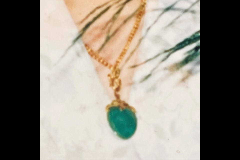 The stolen item is a 24-karat gold necklace with a heart-shaped jade pendant.