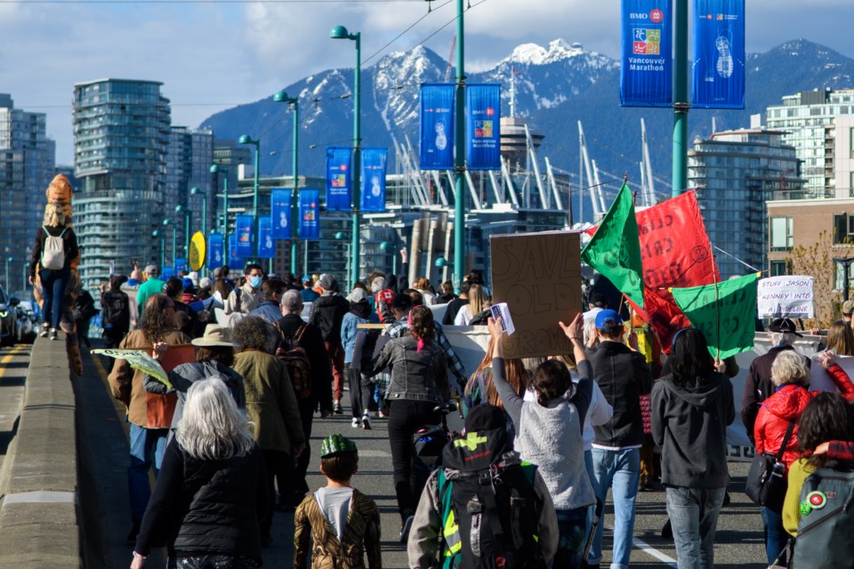 Environmental activists march across Cambie Street Bridge in Vancouver B.C. on April 22, 2022, for Earth day to protest against climate injustice in Canada.