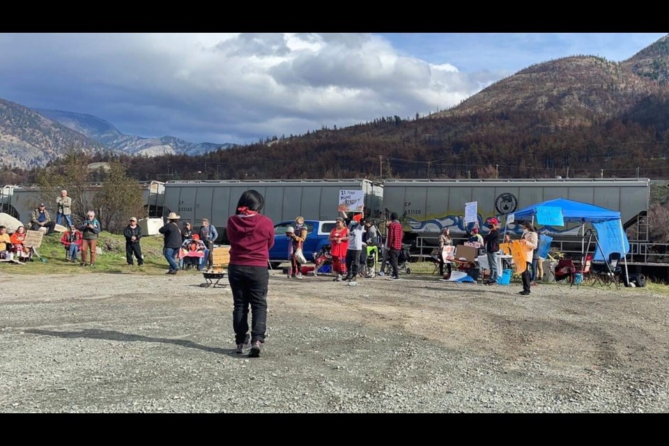 Protesters gather in Lytton as a train passes by on Sunday, Oct. 17.