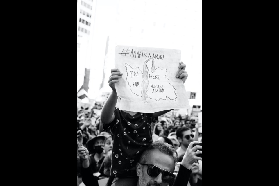 "I'm here for Mahsa Amini" is written over a drawing of Iran. 