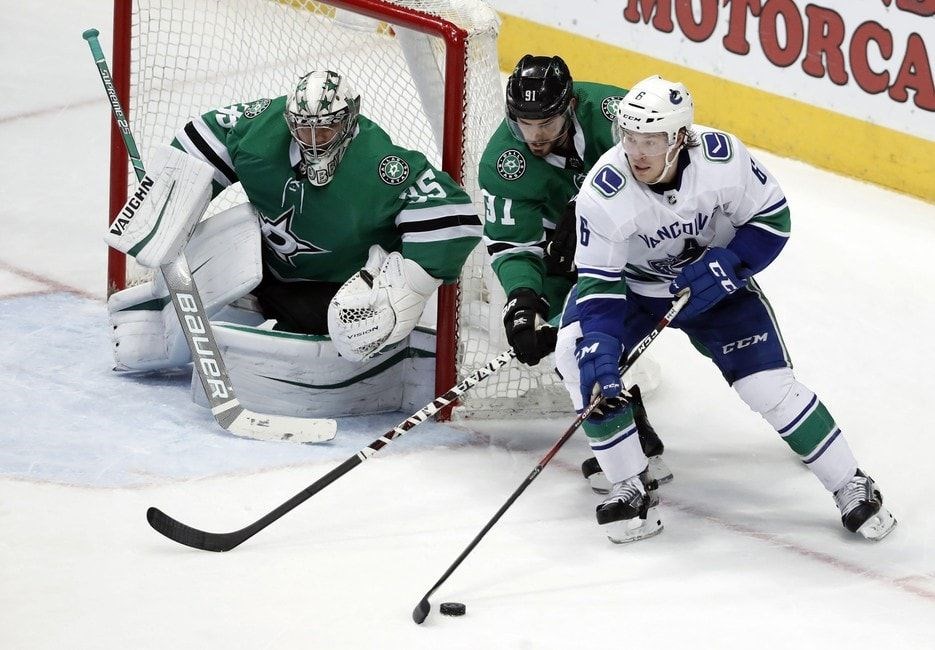 Brock Boeser tries to get past Tyler Seguin to score on Anton Khudobin, Tony Gutierez, CP